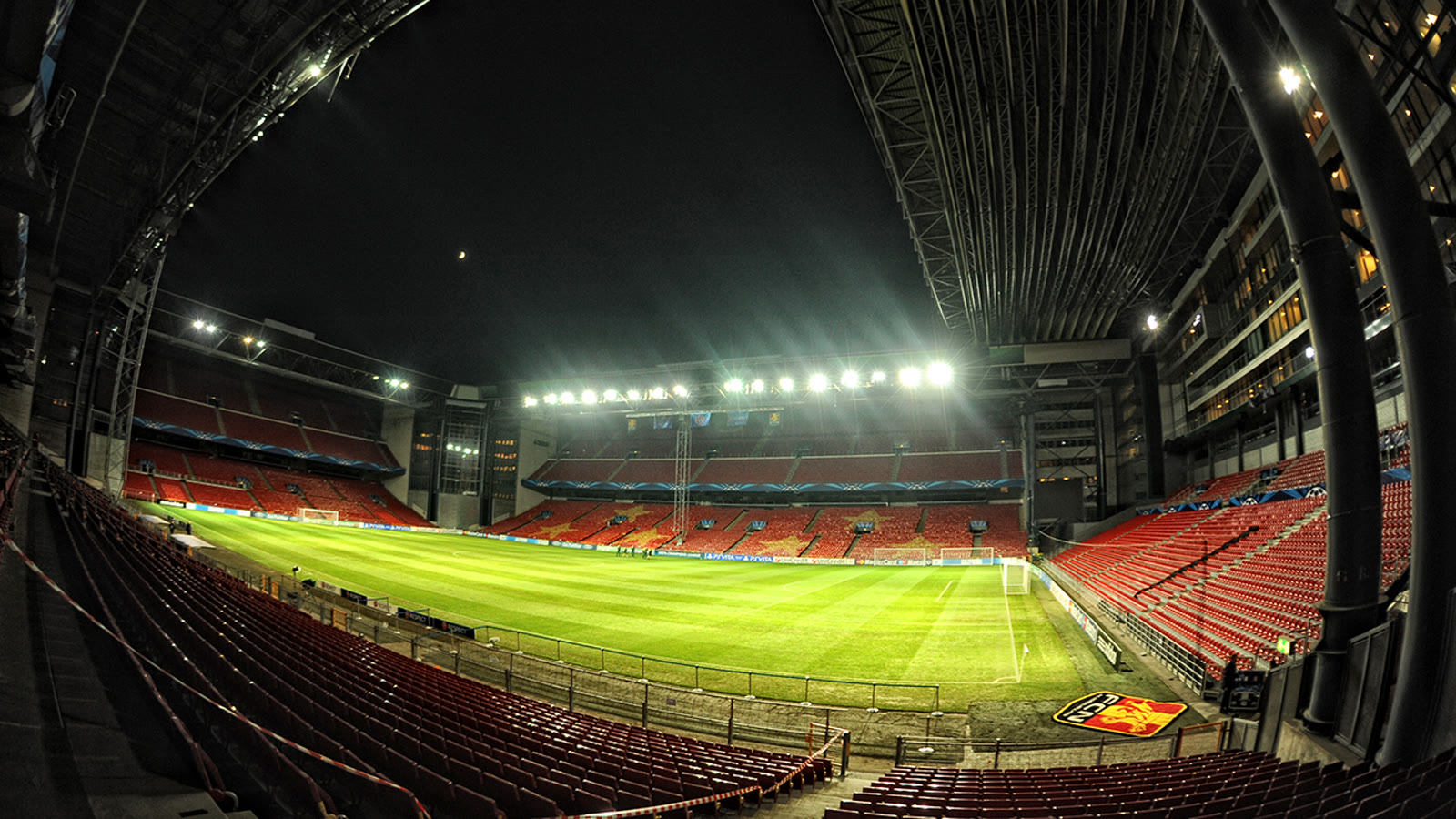 Parken i København oplyst om aftenen, tomt stadion med grøn bane